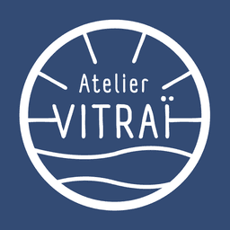 Logo de la marque Atelier Vitraï. Logo circulaire blanc sur un fond bleu.